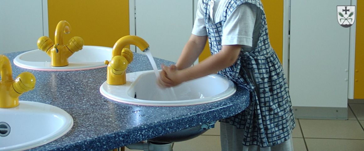 Kind beim Händewaschen im WC-Bereich des Kindergartens